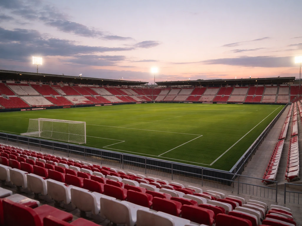 Empty football stadium stand with a subtle club-themed red-and-white color mood in Castellón at dusk.