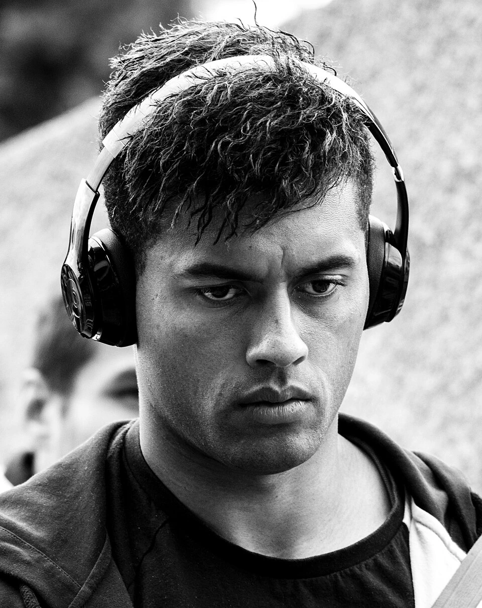 Ben Volavola in a black-and-white portrait wearing headphones