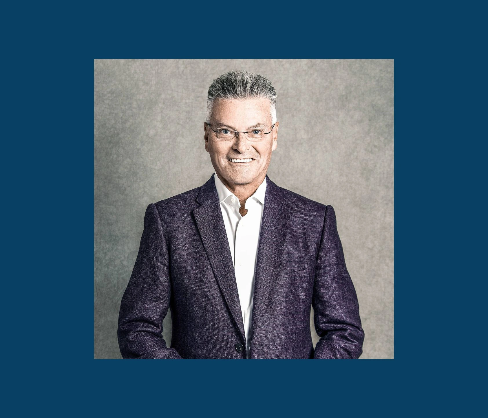 Portrait photo of George Vassallo in a suit against a neutral background