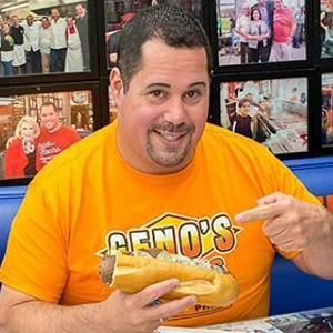 Portrait of Geno Vento holding a cheesesteak in a Geno's shirt