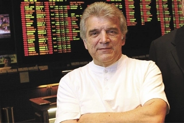 Jimmy Vaccaro standing in a sportsbook with betting boards behind him