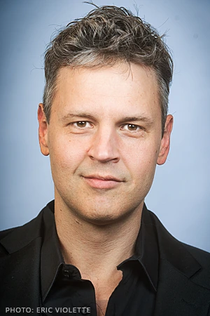 Head-and-shoulders portrait of Eric Violette against a plain blue background